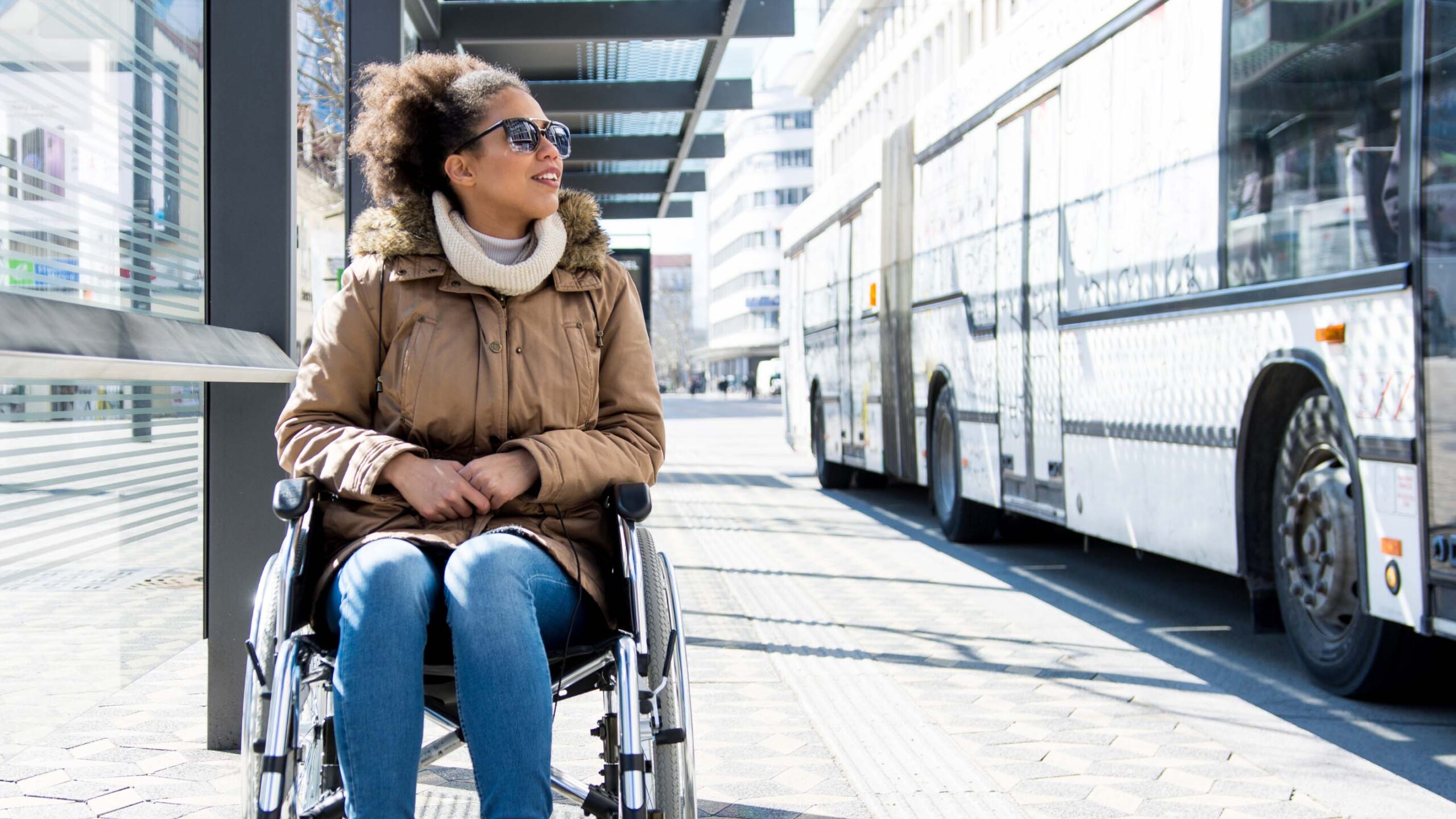 Girl in wheelchair waiting for transit bus